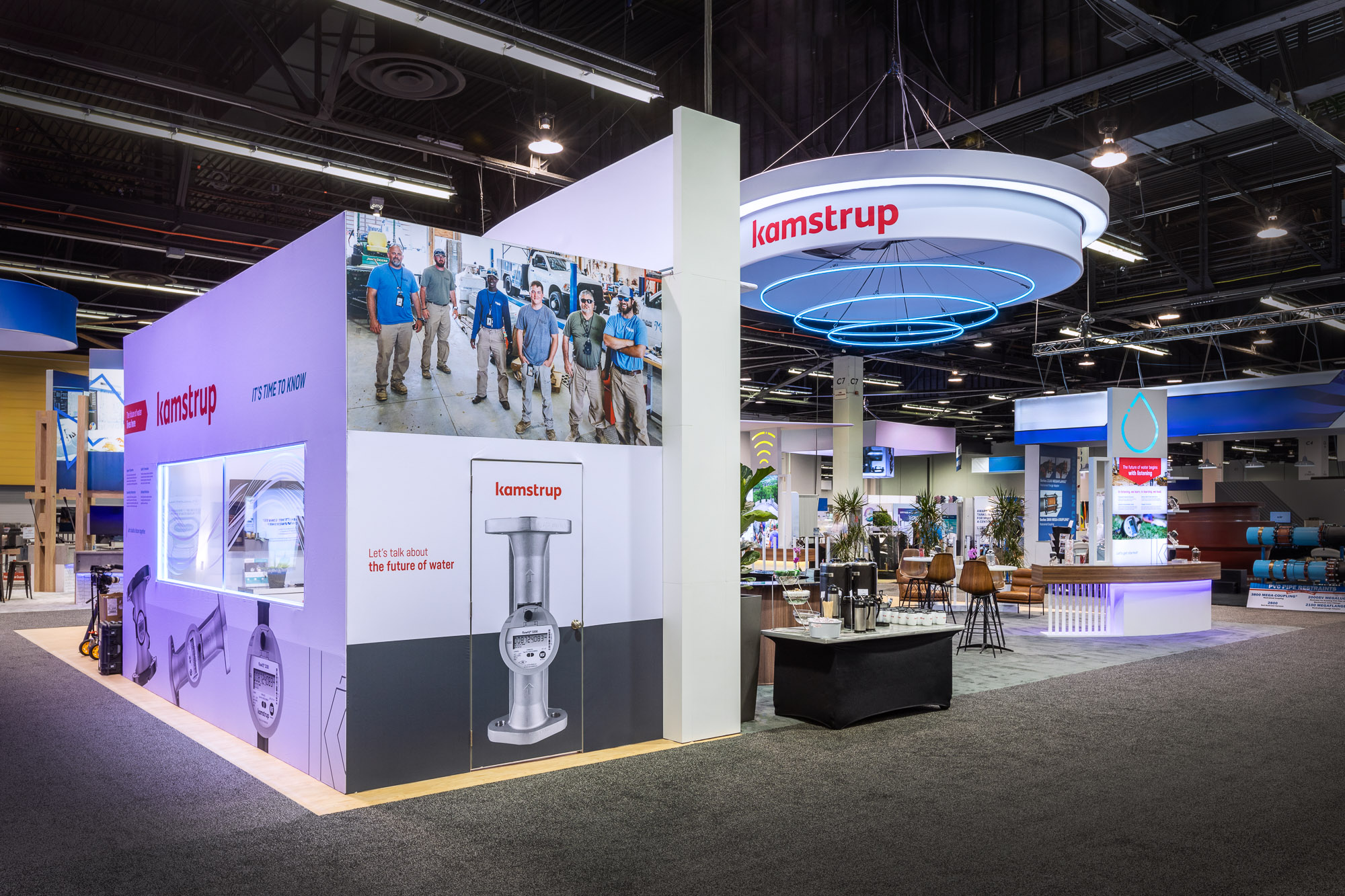 Kamstrup booth interior with demo stations and LED lighting